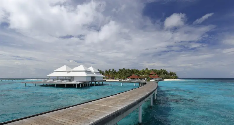 Wooden jetty to overwater villas over a turquoise lagoon in the Maldives