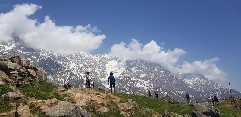 Group of trekkers on a Himalayan trail with snow peaks
