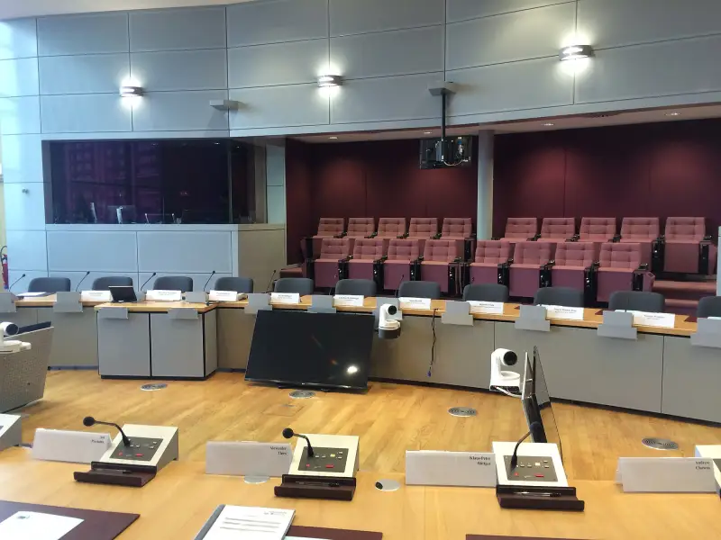 Modern conference room with rows of seats and microphones